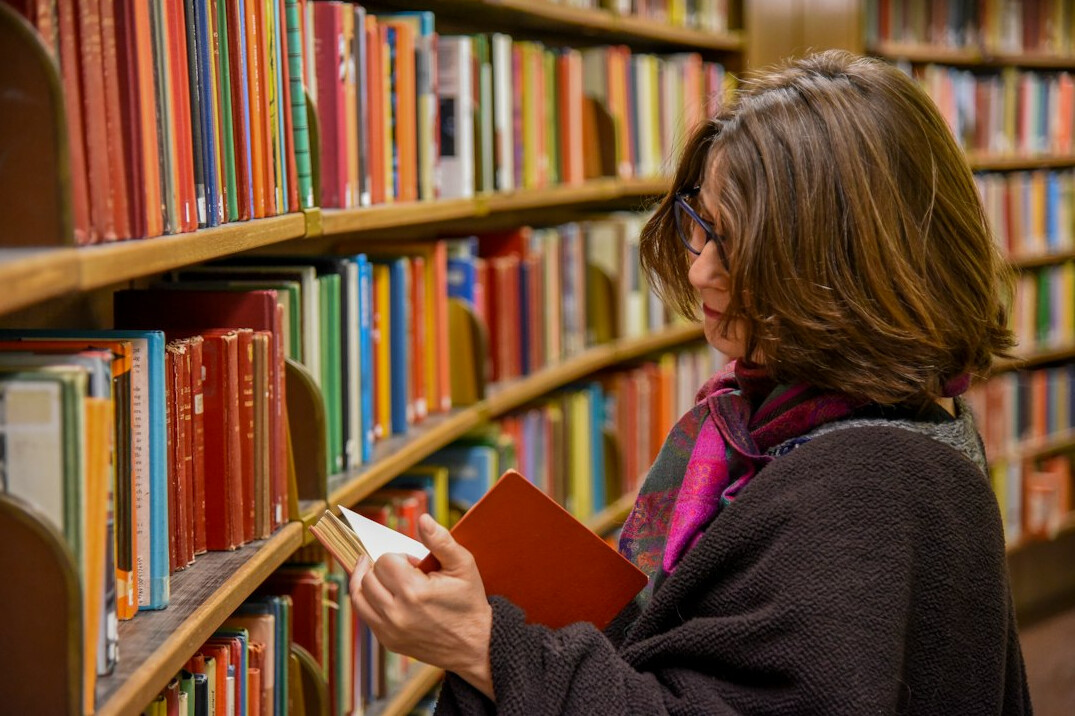 Person reading a book in a quiet library reading room